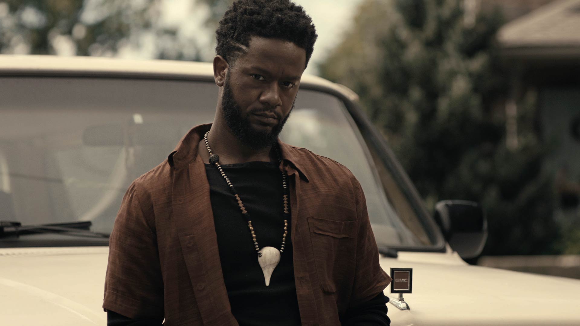 man with bone necklace stares down with no fear