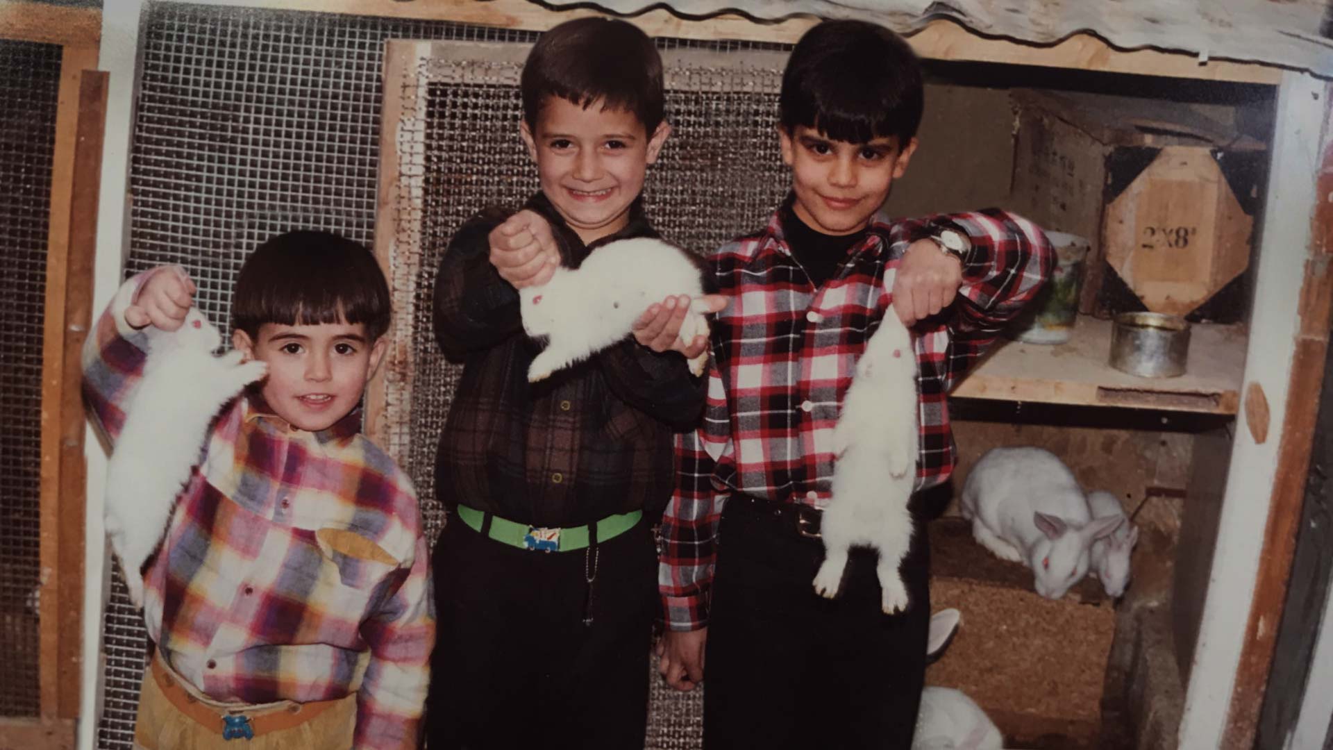 3 kids with white rabbits they caught