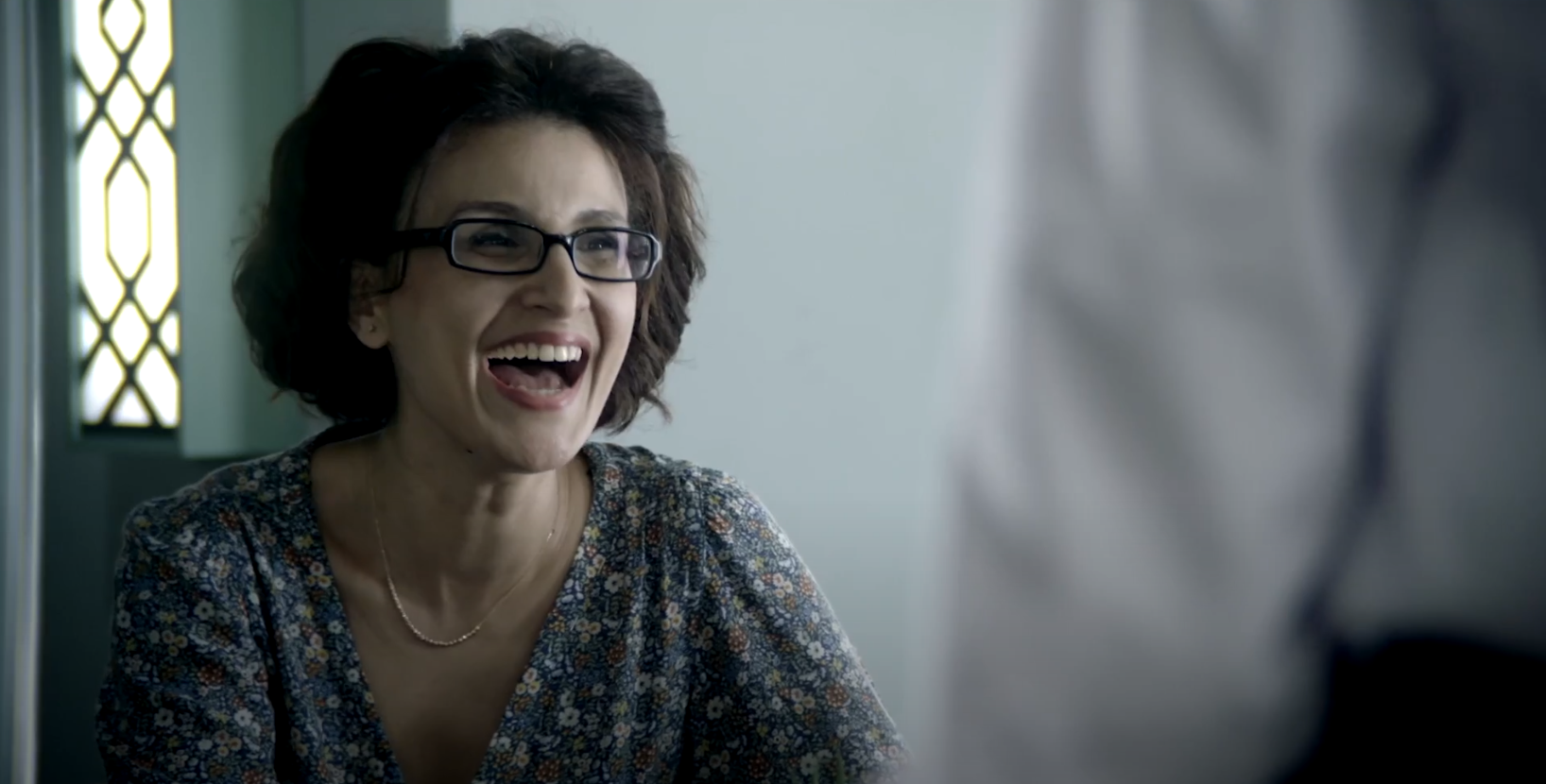 woman with glasses smiling and laughing
