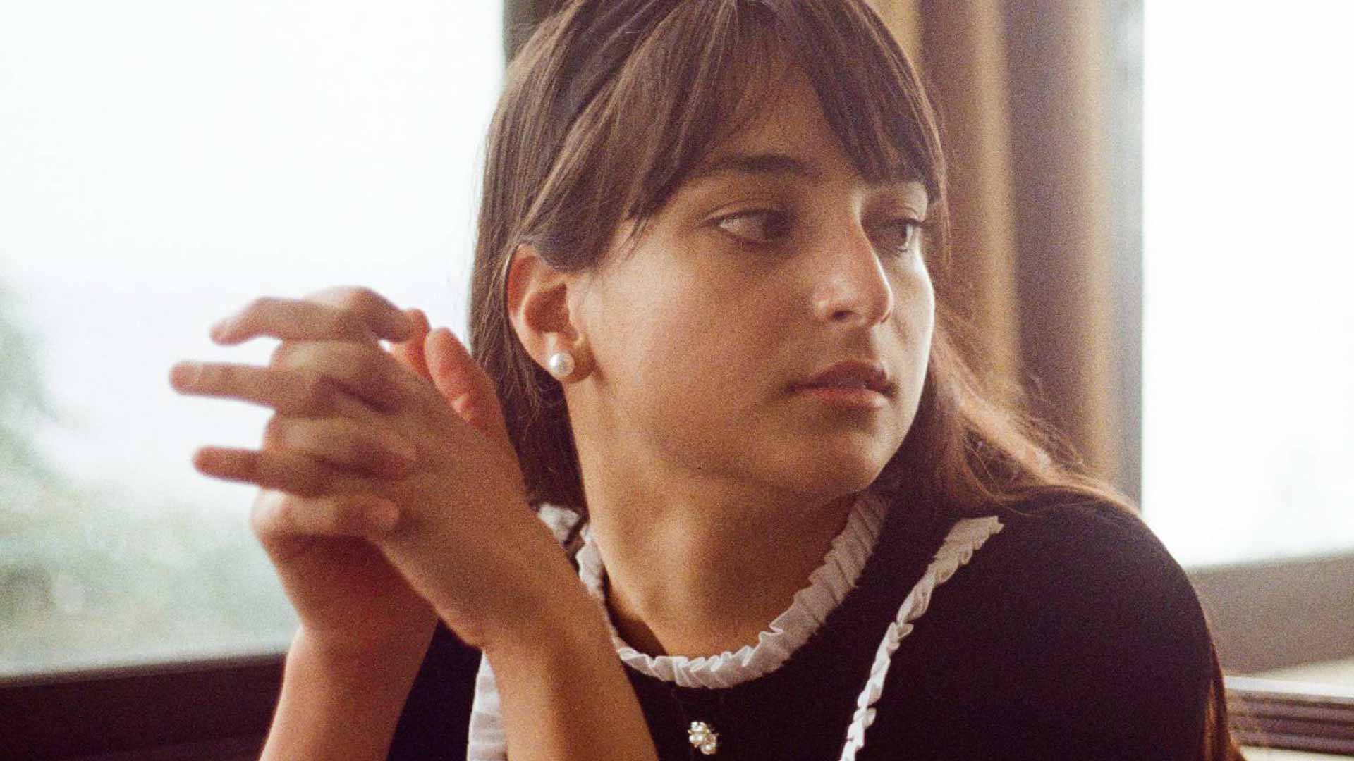 woman in formal wear looks displeased with hands clasped