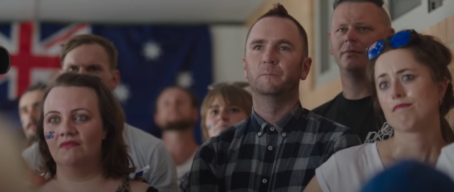 man with mowhawk in front of english flag