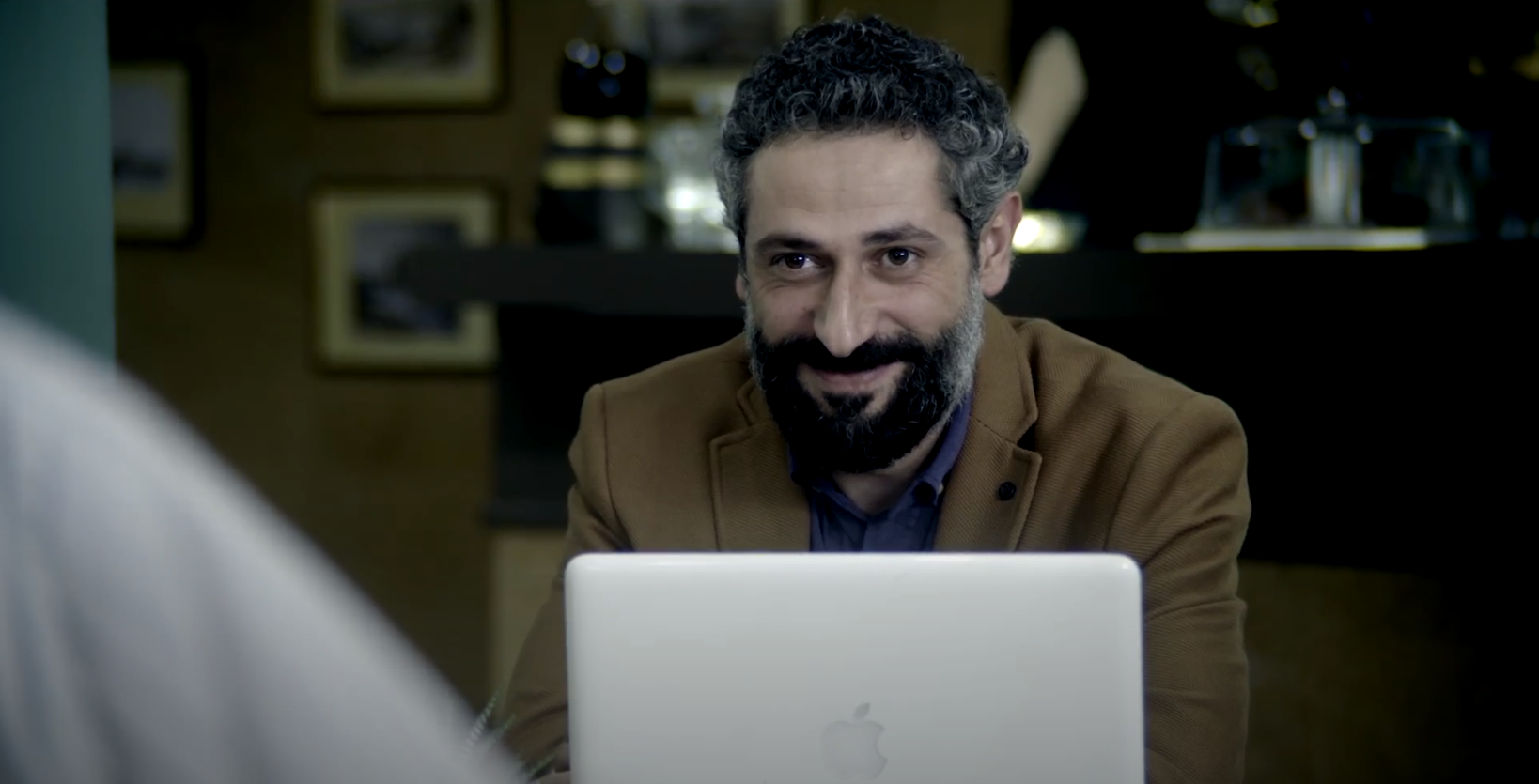 man sitting with his macbook computer